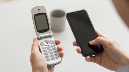 manos sosteniendo telefonos celulares viejos y nuevos generated with Z-Image